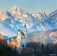 Bild på The famous Neuschwanstein Castle in the background of snowy mountains at sunrise in Germany Beautiful spring landscape with castle mountain peaks and green trees Landmarks in Europe Travel